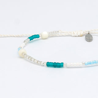 Close-up of a beaded bracelet with blue, silver, and white beads on a white background