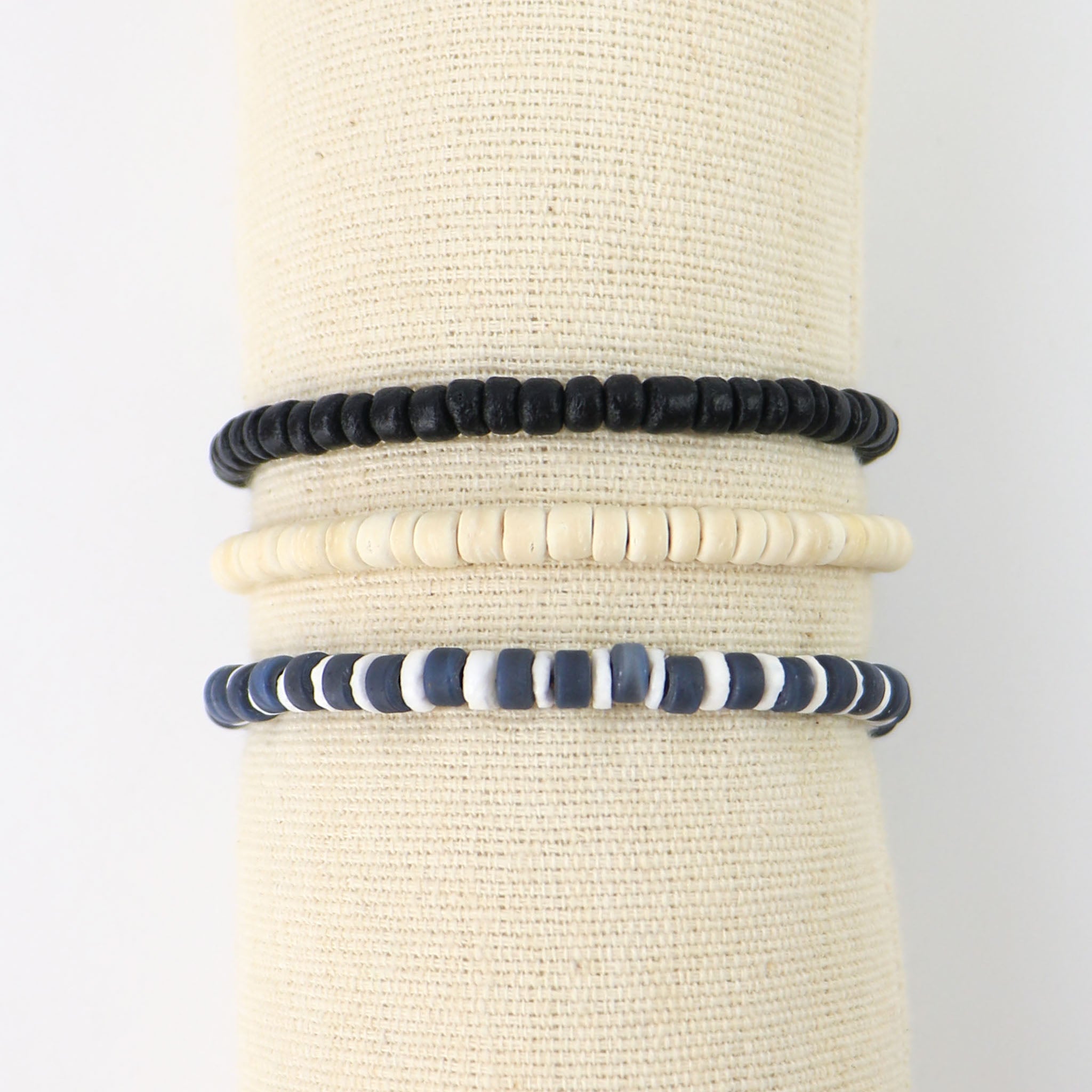 Set of three beaded bracelets in black, grey and cream, styled by the pineapple team so you don't have to! three individual bracelets featuring shell, frosted glass, coconut wood and wax polyester cord.
