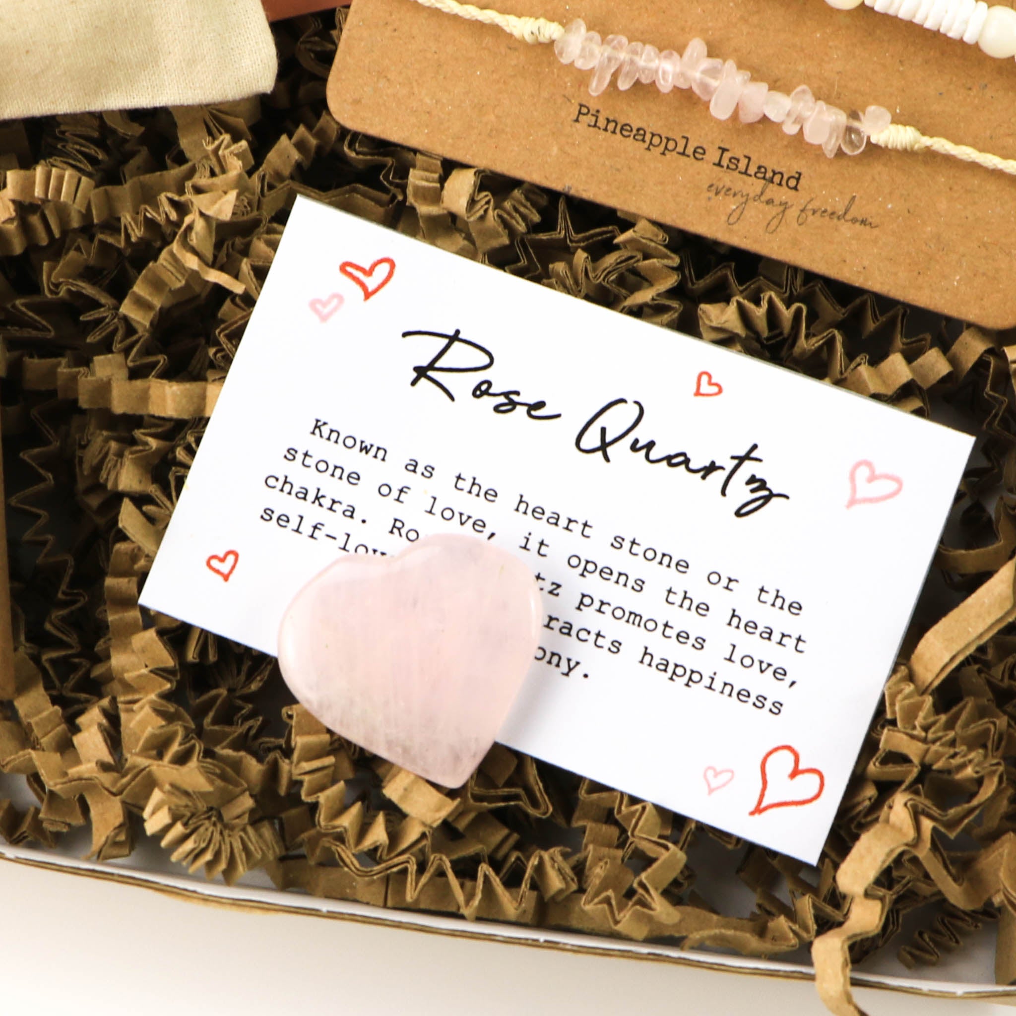 Heart-shaped rose quartz gemstone with a info card on the benefits and qualities of rose quartz crystal.