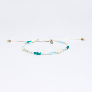 Beaded bracelet with blue, silver, and white beads on a white background
