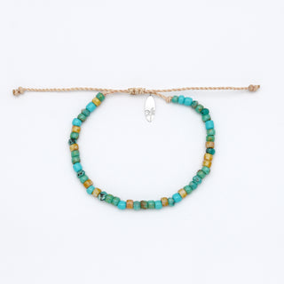 Beaded bracelet with turquoise and yellow beads on a white background