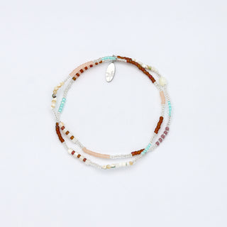 Natural tone beaded bracelet on a white background