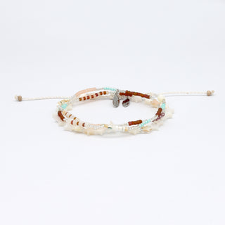 Two beaded bracelets in neutral tones and star beads on a white background