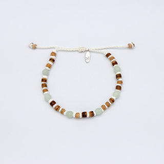 Beaded bracelet with brown wood, white shell, and light blue stone beads on a white background