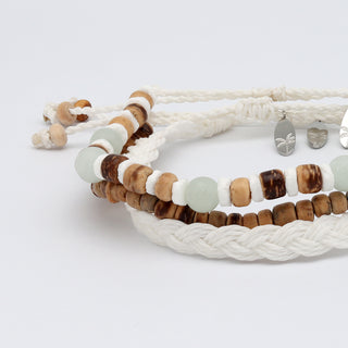Set of beaded bracelets with braided and beaded designs stacked up on a white background