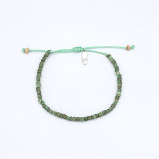 Green beaded bracelet on a white background