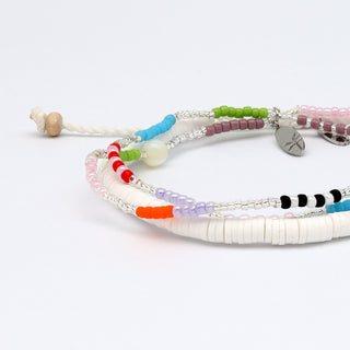 Colorful beaded bracelet and white beaded bracelet close up on a white background
