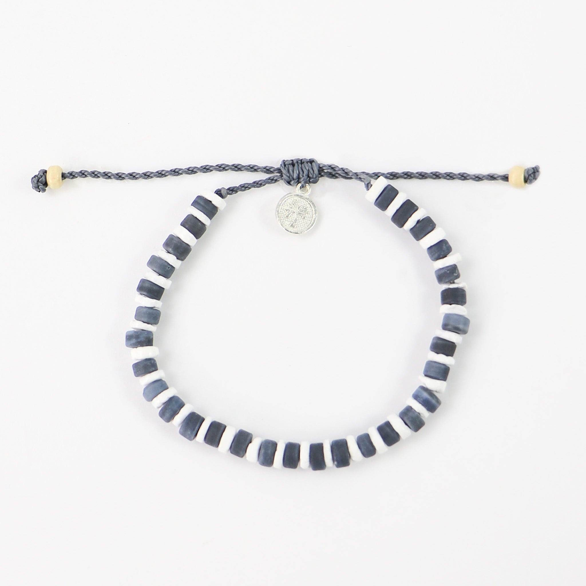 Grey and white beaded bracelet. White puka shell disc beads in between frosted grey glass beads, all threaded on our durable wax polyester cord and finished with our signature textured palm tree tag.